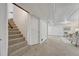 Finished basement featuring a staircase, door, and living area with carpet flooring at 1906 S Vrain St, Denver, CO 80219