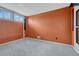 Carpeted bedroom with an orange accent wall and a pair of windows for natural light at 1906 S Vrain St, Denver, CO 80219