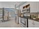 Open-concept kitchen with stainless steel appliances, light-colored walls and an adjacent dining area at 1906 S Vrain St, Denver, CO 80219