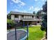 Expansive backyard with a trampoline, patio, lush lawn, and mature trees, perfect for outdoor activities and relaxation at 16639 E Berry Ln, Centennial, CO 80015