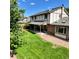 Backyard featuring a covered patio, well-manicured lawn, mature trees, and a gravel border, creating a serene outdoor space at 16639 E Berry Ln, Centennial, CO 80015