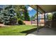 Lush backyard featuring a green lawn, mature trees, trampoline, and a covered patio, creating a welcoming outdoor space at 16639 E Berry Ln, Centennial, CO 80015