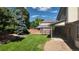 Large backyard with green grass, mature trees, trampoline, and a covered patio, perfect for outdoor activities and relaxation at 16639 E Berry Ln, Centennial, CO 80015