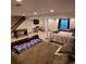 The basement area features multiple beds, a game table, stairs, and bright light from a window, ideal for relaxation at 16639 E Berry Ln, Centennial, CO 80015