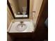 Powder room featuring white sink, vanity, dark wood floors, and a framed mirror at 16639 E Berry Ln, Centennial, CO 80015