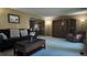 Spacious living room with neutral carpet, large cabinet and arched entryway to adjacent dining area at 16639 E Berry Ln, Centennial, CO 80015