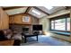 Living room features vaulted ceilings, skylights, brick fireplace, wood-paneled walls, and a cozy window seat at 16639 E Berry Ln, Centennial, CO 80015