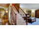 Charming staircase features carpeted steps and wood banister, leading to the home's upper level at 16639 E Berry Ln, Centennial, CO 80015