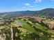 Picturesque aerial view of a lush golf course community surrounded by striking red rock formations and rolling hills at 6835 Surrey Trl, Littleton, CO 80125