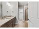 Well-lit bathroom with double vanity, tile floors, neutral colors, and separate shower and bath areas at 6835 Surrey Trl, Littleton, CO 80125
