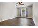Bright bedroom with hardwood floors, a ceiling fan, neutral paint, and natural light from the window at 6835 Surrey Trl, Littleton, CO 80125
