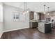 The dining room features stylish pendant lighting and views into the kitchen with stainless steel appliances at 6835 Surrey Trl, Littleton, CO 80125