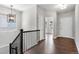 Hallway features hardwood floors, with a view of a decorative light fixture and staircase at 6835 Surrey Trl, Littleton, CO 80125