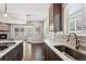 Modern kitchen with dark wood cabinets, white countertops, stainless steel appliances, and natural light at 6835 Surrey Trl, Littleton, CO 80125