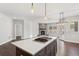 Open concept layout with a view of the kitchen island and living space with fireplace at 6835 Surrey Trl, Littleton, CO 80125