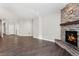 Open living space with stone fireplace, hardwood floors, and ample natural light from the windows at 6835 Surrey Trl, Littleton, CO 80125