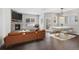 Open-concept living room with a stone fireplace, sleek furniture, and a modern dining set bathed in natural light at 6835 Surrey Trl, Littleton, CO 80125