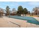 Large, covered community pool surrounded by mature trees and featuring a pool house and covered seating area at 11861 E Yale Ct, Aurora, CO 80014