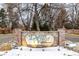 Elegant brick community sign for The Dam West, a covenant protected community, surrounded by landscaping at 11861 E Yale Ct, Aurora, CO 80014