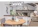 Open dining area with modern light fixture and seating for four, flows into the adjacent living room with fireplace at 11861 E Yale Ct, Aurora, CO 80014