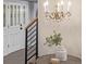 Bright entryway with a stylish chandelier, white front door with decorative glass, and wood floors at 11861 E Yale Ct, Aurora, CO 80014