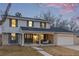 Charming two-story home featuring a brick facade, covered porch with seating area, and attached garage at 11861 E Yale Ct, Aurora, CO 80014