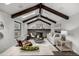 Bright living room featuring vaulted ceiling, wood beams, skylights, brick fireplace, and modern decor at 11861 E Yale Ct, Aurora, CO 80014