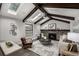 Living room with vaulted ceiling, exposed wood beams, skylights, brick fireplace, and open layout at 11861 E Yale Ct, Aurora, CO 80014