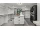 Spacious walk-in closet with custom shelving, center island, and laundry area at 11861 E Yale Ct, Aurora, CO 80014