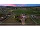 Large parcel of land with a ranch-style house, white fencing, and mature trees against a colorful sunset at 1851 E 138Th Ave, Brighton, CO 80602