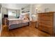 Bright bedroom featuring hardwood floors, a wooden bed frame, and mountain views from the window at 1851 E 138Th Ave, Brighton, CO 80602