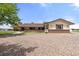 Ranch-style home featuring a brick facade, covered porch and a gravel driveway under a blue sky at 1851 E 138Th Ave, Brighton, CO 80602