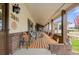 Inviting covered porch with brick accents, outdoor seating and a view of the front yard at 1851 E 138Th Ave, Brighton, CO 80602