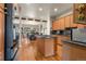 Open-concept kitchen with wood cabinets, granite counters, and a central island at 1851 E 138Th Ave, Brighton, CO 80602