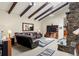 Bright living room with vaulted ceiling, exposed beams, stone fireplace, and leather furniture at 1851 E 138Th Ave, Brighton, CO 80602