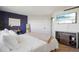 Cozy bedroom with a desk and a decorative mirror and a large TV at 550 E 12Th Ave # 810, Denver, CO 80203