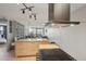 Open floorplan living with kitchen island, dark range hood, and open living room in a modern condo at 550 E 12Th Ave # 810, Denver, CO 80203