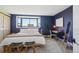 A spacious main bedroom features a bed, desk, large window with city views, and navy blue walls at 550 E 12Th Ave # 810, Denver, CO 80203