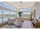 Comfortable seating area with large windows and panoramic views, accented by indoor greenery and a stylish piano at 550 E 12Th Ave # 810, Denver, CO 80203