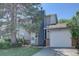 Two-story home with gray siding, brick accents, attached garage, and mature landscaping at 562 W Crestline Cir # 7D, Littleton, CO 80120