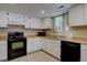 Functional kitchen with tile flooring, white cabinets, and black appliances at 562 W Crestline Cir # 7D, Littleton, CO 80120