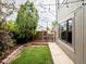 Backyard patio with a manicured lawn, garden beds, a wooden privacy fence, and decorative string lights at 1233 S Yosemite Way # 74, Denver, CO 80247
