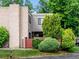Townhouse featuring a brick chimney, a red fence, lush landscaping and an attached garage at 1233 S Yosemite Way # 74, Denver, CO 80247