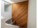 View of an interior hallway featuring a wood accent wall, white walls, and staircase at 1233 S Yosemite Way # 74, Denver, CO 80247