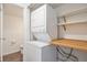 Efficient laundry area with a stacked washer and dryer, plus wooden shelving for storage at 1233 S Yosemite Way # 74, Denver, CO 80247