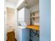 Laundry closet with a stacked washer and dryer unit, shelving, and wooden counter space at 1233 S Yosemite Way # 74, Denver, CO 80247