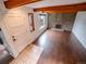 Open living room with a brick fireplace, hardwood flooring, exposed beams, and updated windows providing lots of light at 1233 S Yosemite Way # 74, Denver, CO 80247