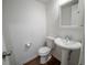 Powder room featuring a toilet and pedestal sink on dark wood-look flooring with a wall mirror at 1233 S Yosemite Way # 74, Denver, CO 80247