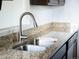 The kitchen features stainless steel sink, granite counters and a gooseneck faucet at 1233 S Yosemite Way # 74, Denver, CO 80247