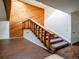 A staircase with wooden banister and carpeted steps is illuminated by a skylight and features a wood accent wall at 1233 S Yosemite Way # 74, Denver, CO 80247